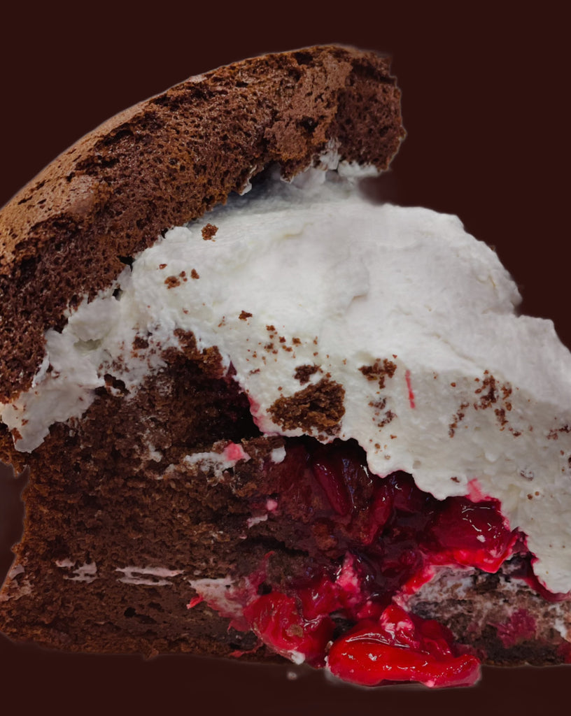 slice of flourless chocolate cake with cherry compte and whipped cream