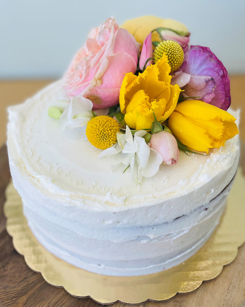 vanilla buttercream cake topped with fresh flowers